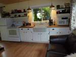 
                  Another view of the kitchen/living area with leather
                  loveseat and laminate flooring - ideal for your pets.